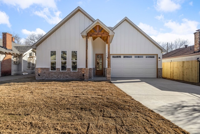 modern farmhouse with brick siding, board and batten siding, fence, a garage, and driveway