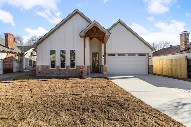 modern inspired farmhouse featuring brick siding, concrete driveway, an attached garage, board and batten siding, and fence