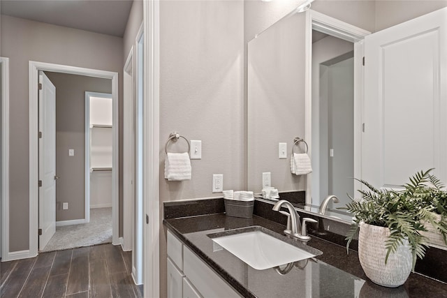 bathroom with vanity, baseboards, and wood finished floors