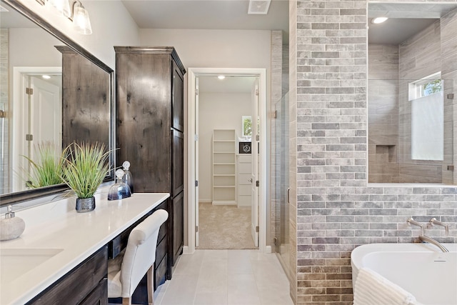 full bathroom with visible vents, tile patterned floors, vanity, a freestanding tub, and a shower stall