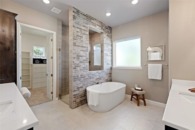 full bathroom with a stall shower, recessed lighting, a freestanding bath, and vanity