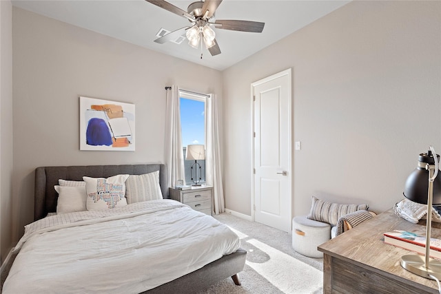 carpeted bedroom with ceiling fan and baseboards