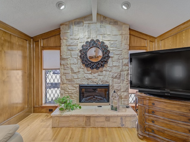 113 S Beltwoods Dr, Desoto, TX 75115 - unfurnished living room featuring vaulted ceiling with beams, a stone fireplace, wood finished floors, and wooden walls