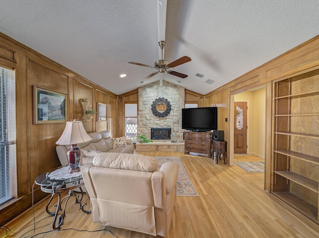 113 S Beltwoods Dr, Desoto, TX 75115 - living room featuring light wood-style floors, lofted ceiling, wooden walls, and a textured ceiling