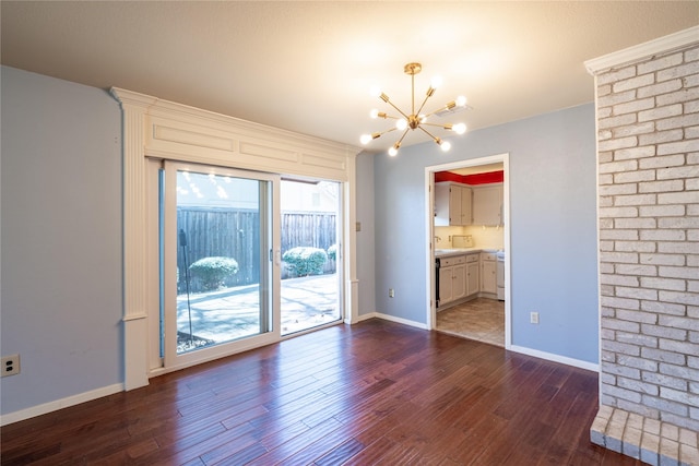 spare room with dark wood-type flooring, visible vents, baseboards, and an inviting chandelier