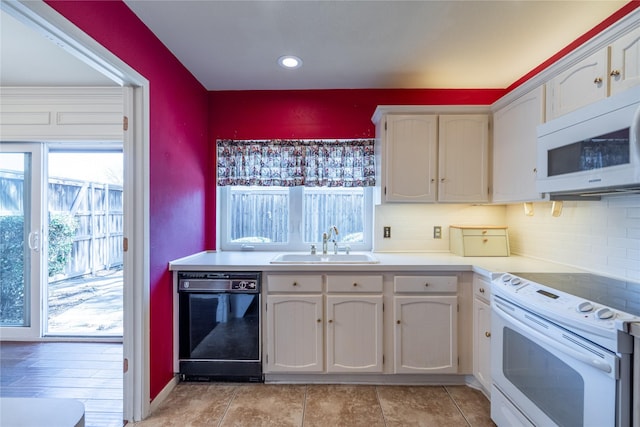 kitchen featuring white appliances, light countertops, a sink, and decorative backsplash