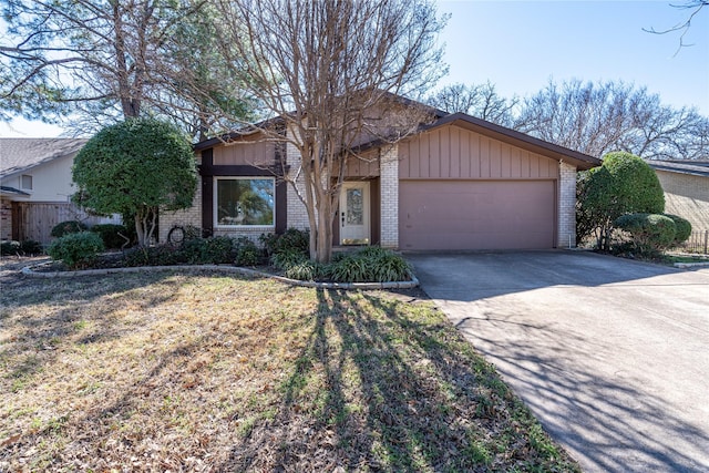 view of front of home featuring a front yard, concrete driveway, brick siding, and an attached garage