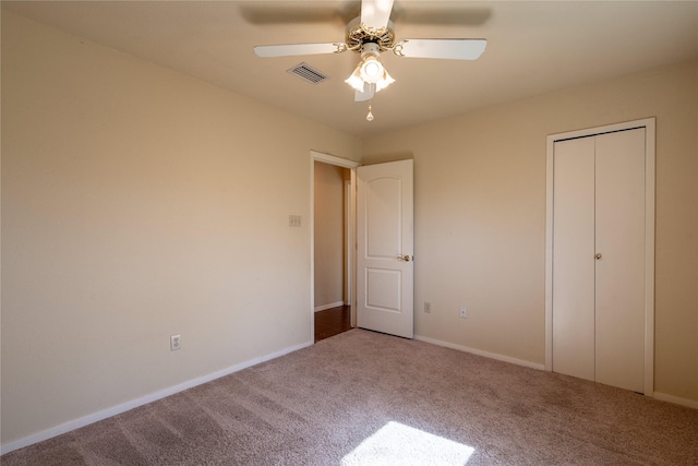 unfurnished bedroom featuring baseboards, visible vents, ceiling fan, and carpet flooring