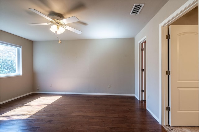 spare room featuring visible vents, baseboards, and wood finished floors