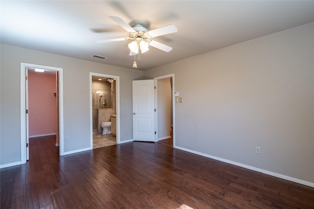 unfurnished bedroom featuring wood finished floors, visible vents, baseboards, a spacious closet, and a closet