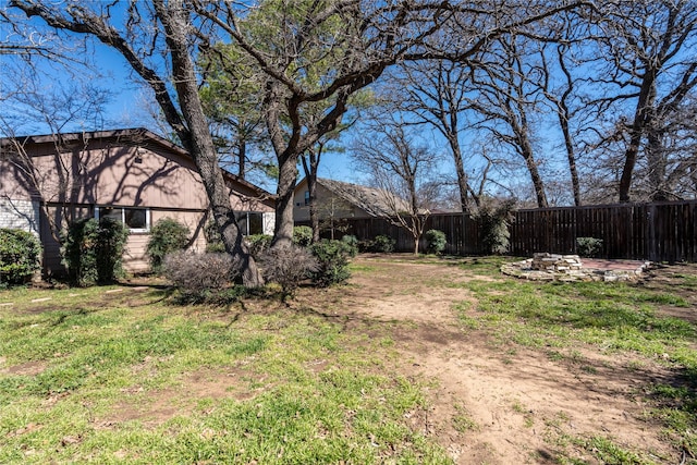 view of yard featuring an outdoor fire pit and fence