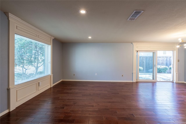 spare room featuring dark wood-style floors, baseboards, visible vents, and recessed lighting