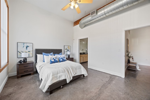 bedroom featuring arched walkways, visible vents, ensuite bathroom, finished concrete floors, and baseboards