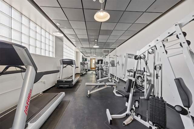 exercise room with a paneled ceiling and visible vents