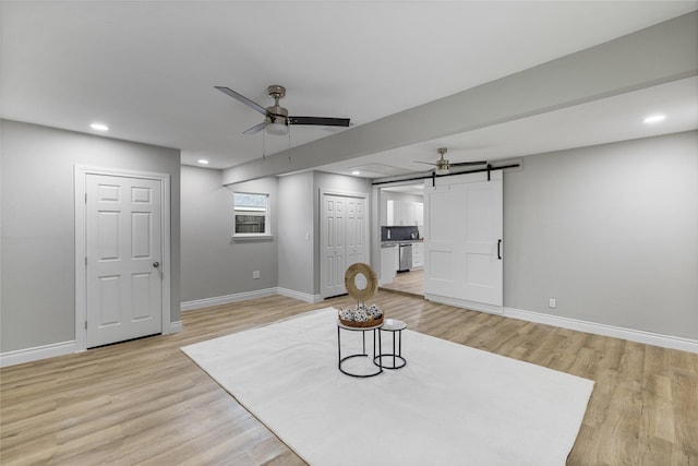 living area featuring a barn door, baseboards, ceiling fan, light wood-style flooring, and recessed lighting