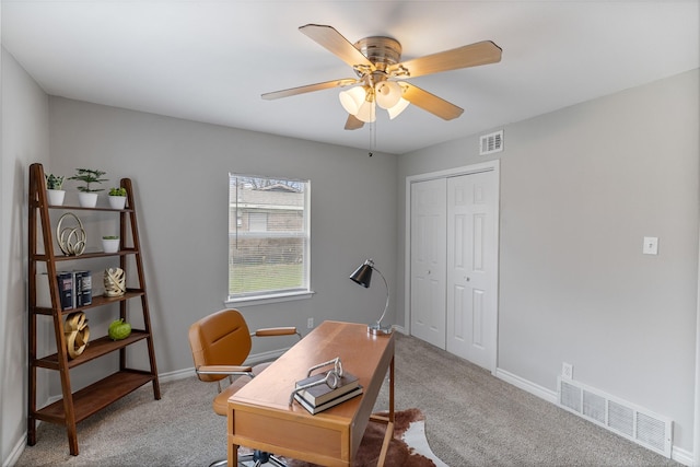 carpeted office with visible vents, ceiling fan, and baseboards