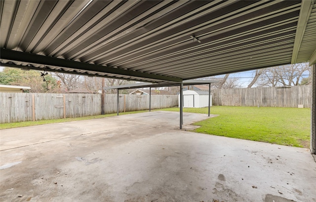 view of patio featuring a storage shed, a carport, an outbuilding, and a fenced backyard