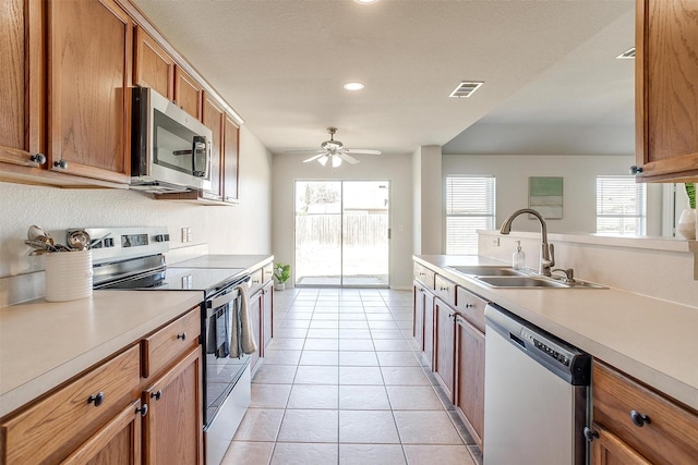 kitchen featuring stainless steel appliances, a sink, visible vents, light countertops, and a wealth of natural light