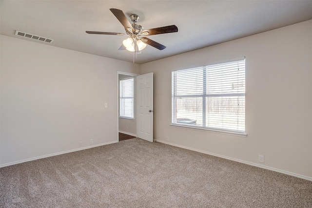 spare room featuring baseboards, carpet, visible vents, and a ceiling fan