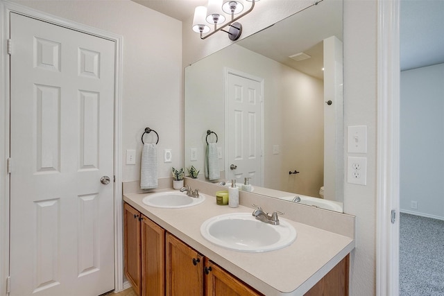 bathroom with visible vents, a sink, toilet, and double vanity