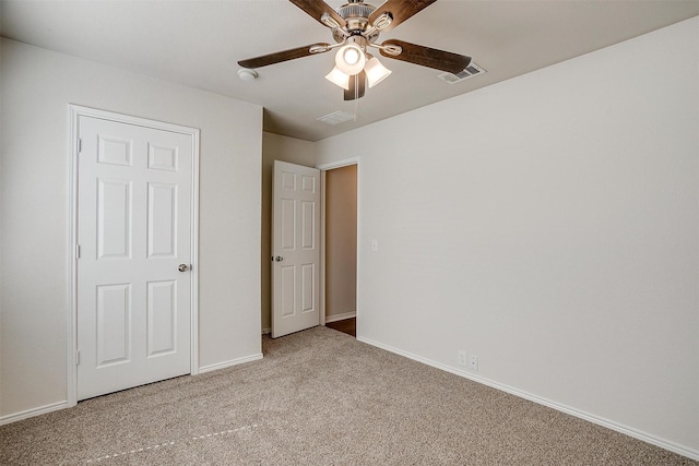 unfurnished bedroom featuring light carpet, visible vents, baseboards, and a ceiling fan