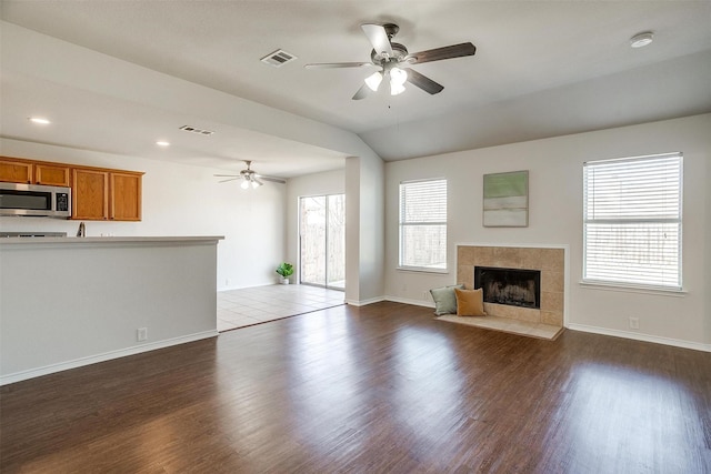 unfurnished living room featuring visible vents, dark wood finished floors, and a fireplace