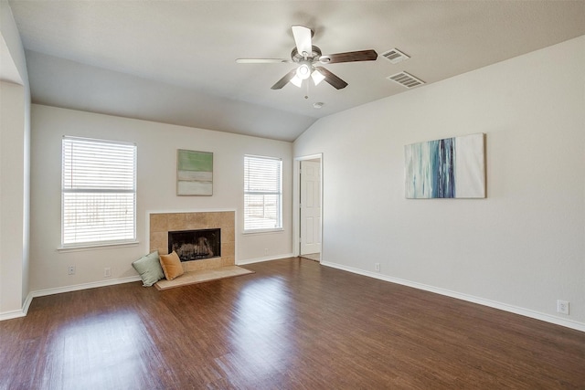 unfurnished living room featuring dark wood-style floors, a tile fireplace, and visible vents