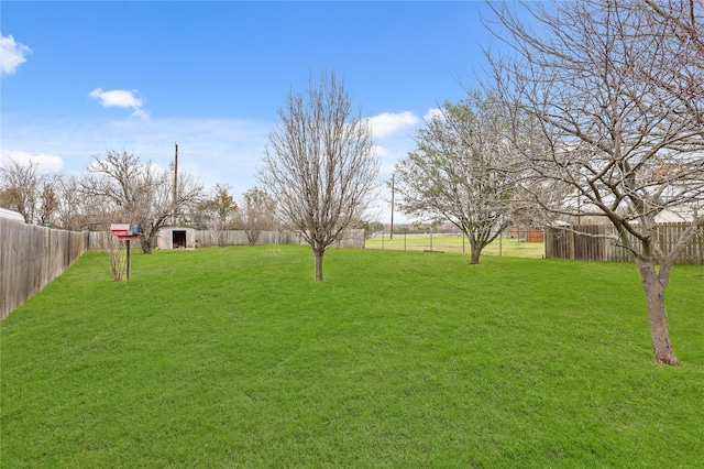 view of yard featuring an outdoor structure and a fenced backyard