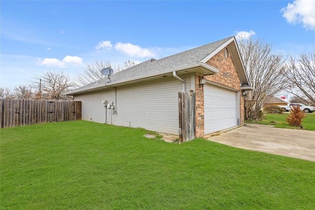 view of side of home featuring a garage, brick siding, fence, a yard, and roof with shingles