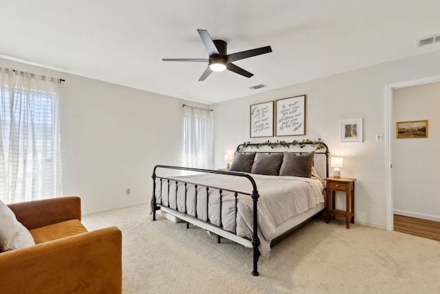 bedroom featuring light colored carpet, visible vents, and baseboards