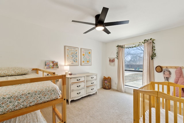 bedroom featuring light carpet, baseboards, and a ceiling fan