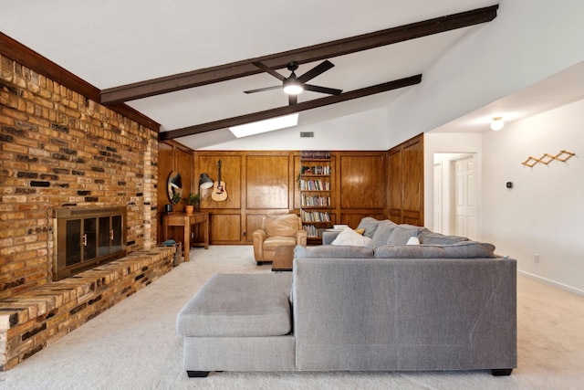 living area with baseboards, light colored carpet, ceiling fan, vaulted ceiling with beams, and a brick fireplace