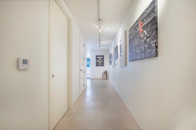 hallway with visible vents and rail lighting