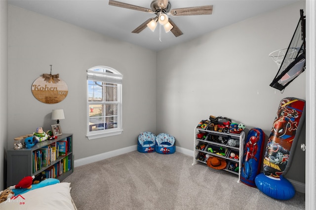 playroom with a ceiling fan, carpet, and baseboards