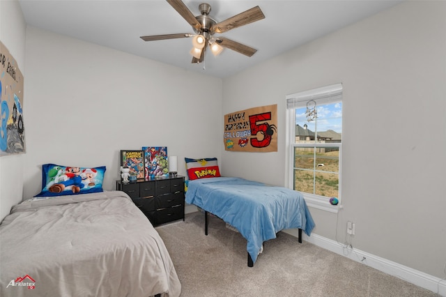 bedroom with light carpet, ceiling fan, and baseboards