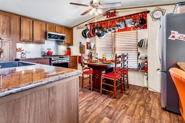 505 County Road 3420, Hawkins, TX 75765 - kitchen with brown cabinets, wood finished floors, vaulted ceiling, stainless steel appliances, and a sink