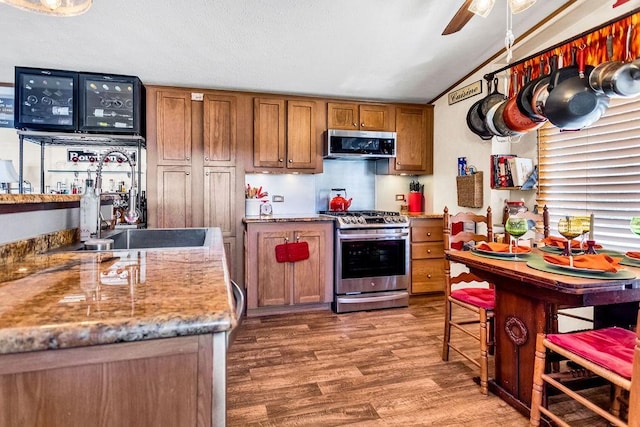 505 County Road 3420, Hawkins, TX 75765 - kitchen with lofted ceiling, appliances with stainless steel finishes, brown cabinets, wood finished floors, and a sink