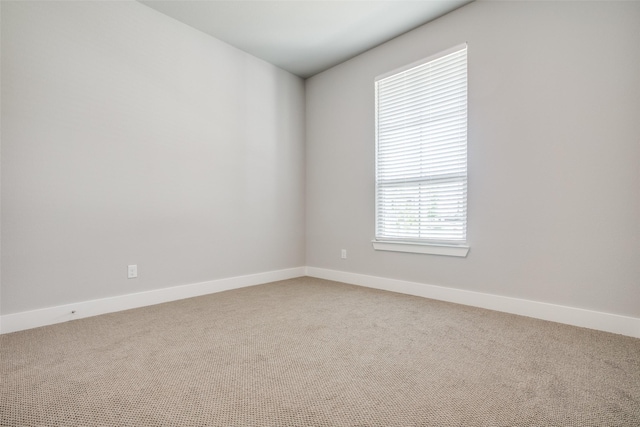 spare room featuring carpet floors and baseboards