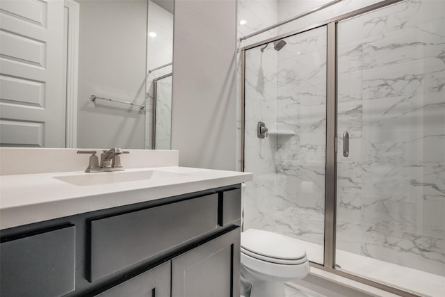 bathroom featuring toilet, marble finish floor, a marble finish shower, and vanity