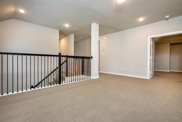 carpeted empty room with baseboards, vaulted ceiling, and recessed lighting