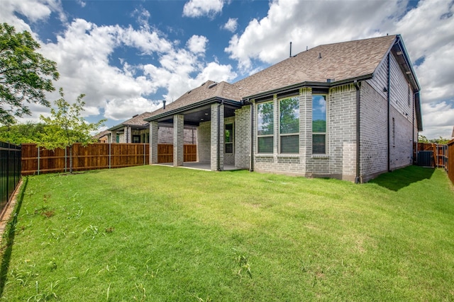 rear view of house with a patio area, brick siding, a yard, and a fenced backyard