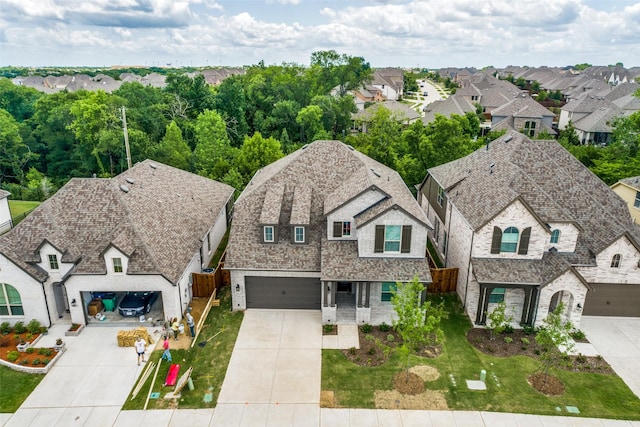 view of front of home featuring driveway, a garage, a shingled roof, a residential view, and brick siding