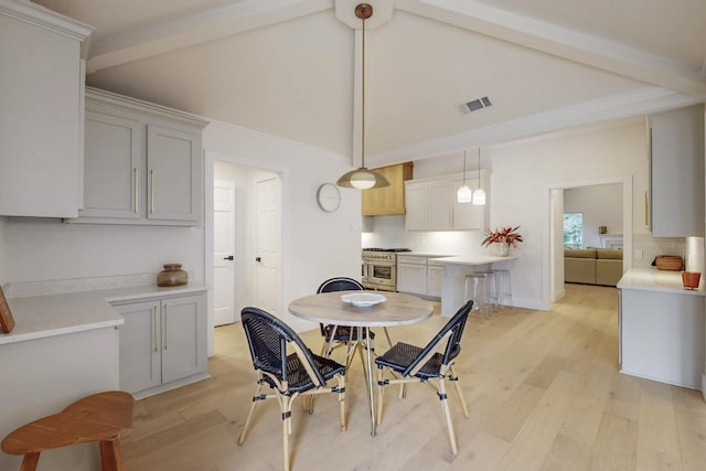 dining area with high vaulted ceiling, light wood-style flooring, visible vents, baseboards, and beam ceiling