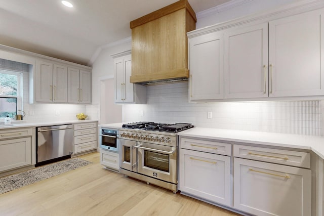 kitchen featuring crown molding, light countertops, appliances with stainless steel finishes, and custom range hood