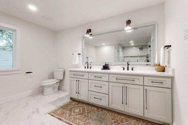 bathroom with a marble finish shower, baseboards, toilet, marble finish floor, and a sink