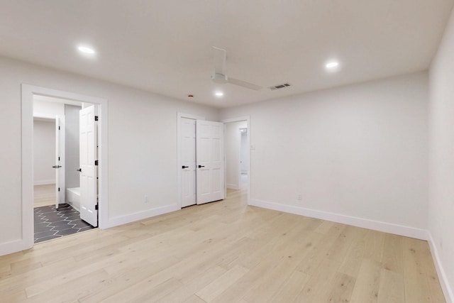 spare room featuring light wood finished floors, recessed lighting, visible vents, and baseboards