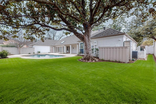 rear view of property featuring brick siding, a lawn, a fenced backyard, and a fenced in pool