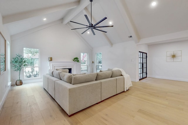 living room featuring baseboards, light wood-style flooring, beamed ceiling, a fireplace, and high vaulted ceiling