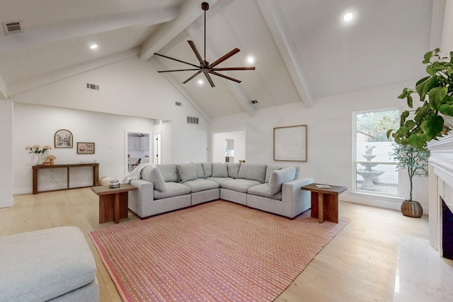 living room featuring light wood-style floors, visible vents, a ceiling fan, and a high end fireplace