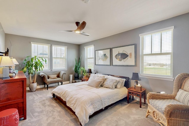 bedroom with multiple windows, light colored carpet, and ceiling fan